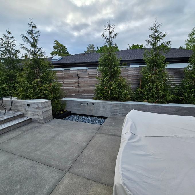 Concrete patio with board-formed walls and an arborvitae screen, Millcreek