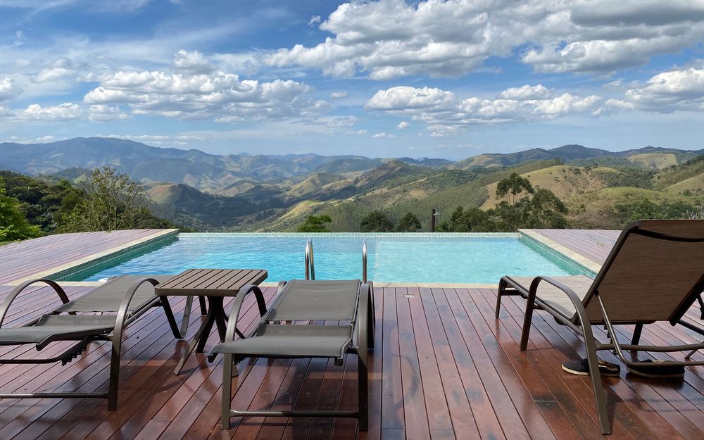 Pool and wood deck with lounge chairs overlooking a mountain valley (stock photo)