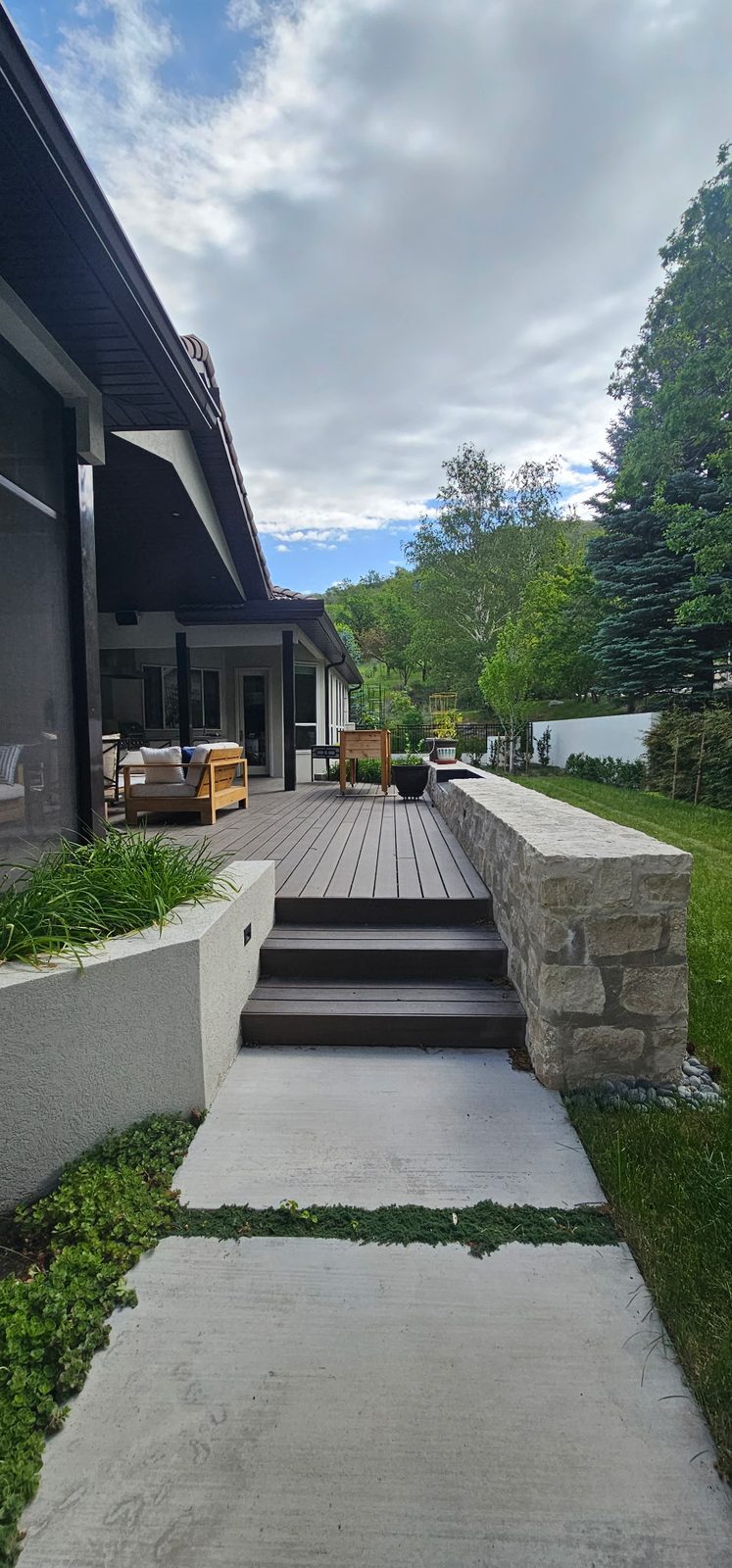 Covered deck with steps down to a concrete walk and stone-capped wall, Emigration Canyon