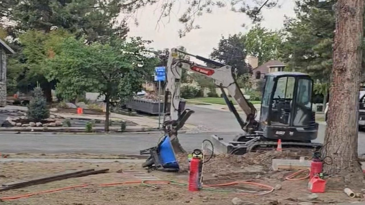 Site prep: mini excavator beside the fresh concrete, Cottonwood Heights
